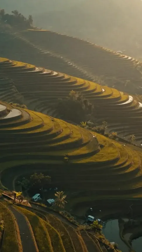 A finished Artquil render: an aerial shot of terraced fields at golden hour, with narration and score generated alongside the picture